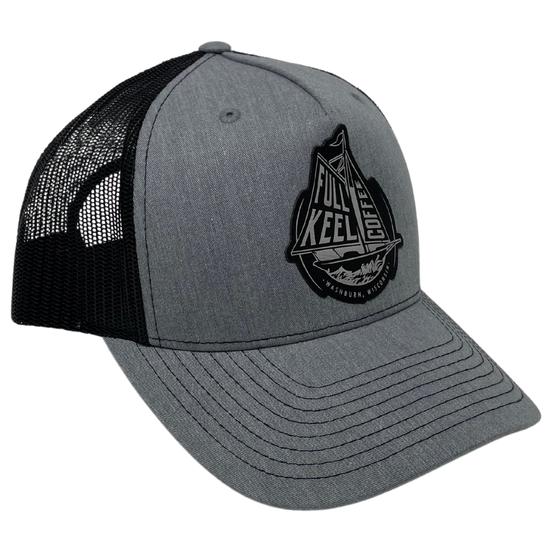 Full Keel Trucker Hat Grey and Black  60% Cotton, 40% Polyester
100% polyester mesh back
Structured, mid-profile, six-panel
Pre-curved contrast stitched visor
Snapback closure
Faux leather patch of full keel coffee logo